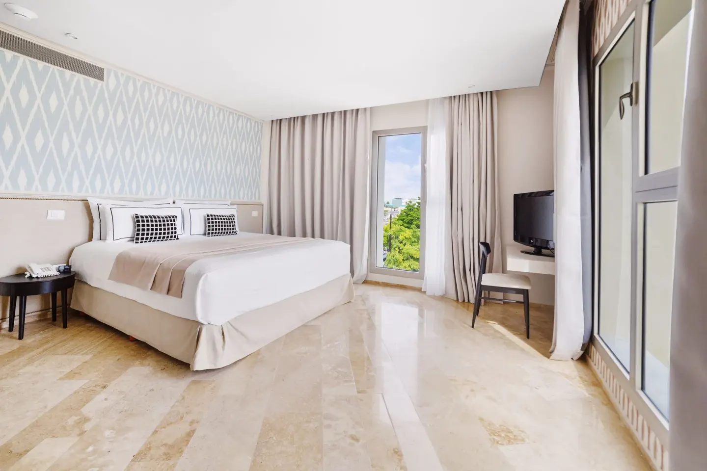 Deluxe Suite Garden View king bed and desk at Privilege Aluxes Isla Mujeres.