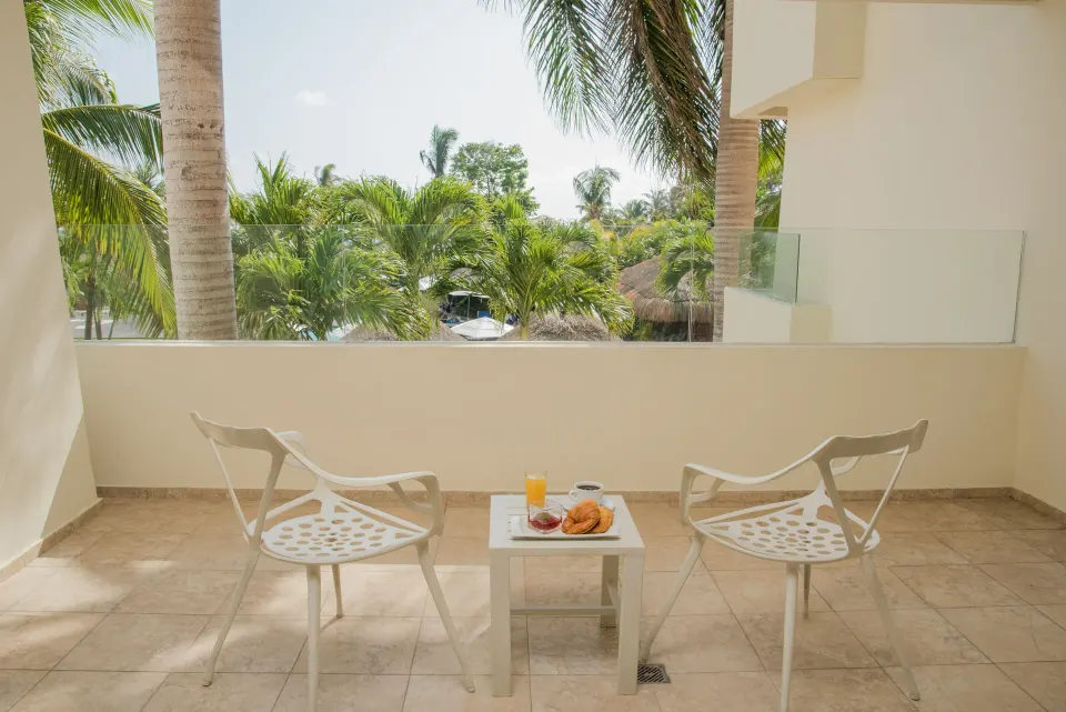 Deluxe Suite Garden View terrace seating amid palms at Privilege Aluxes Isla Mujeres.
