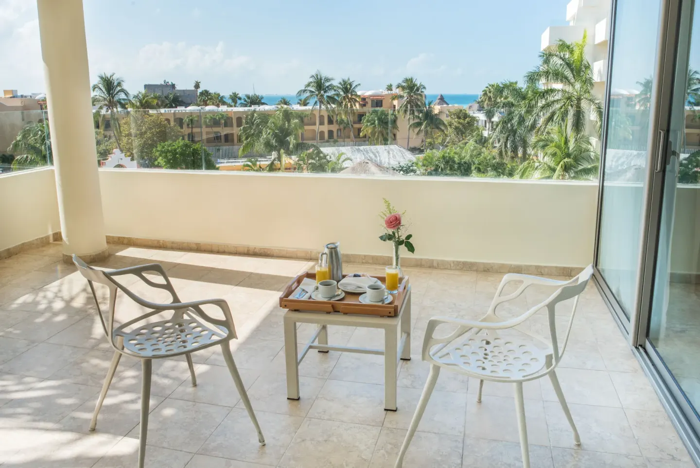 Premium Suite balcony with breakfast tray and ocean glimpse at Privilege Aluxes Isla Mujeres.