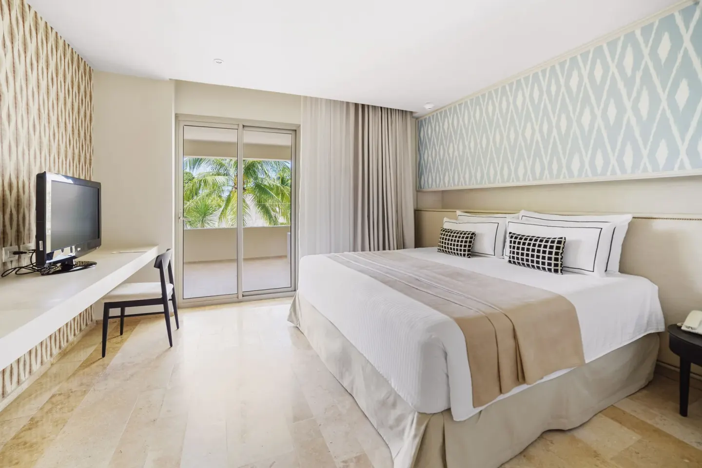Premium Suite bedroom with king bed and balcony doors at Privilege Aluxes Isla Mujeres.