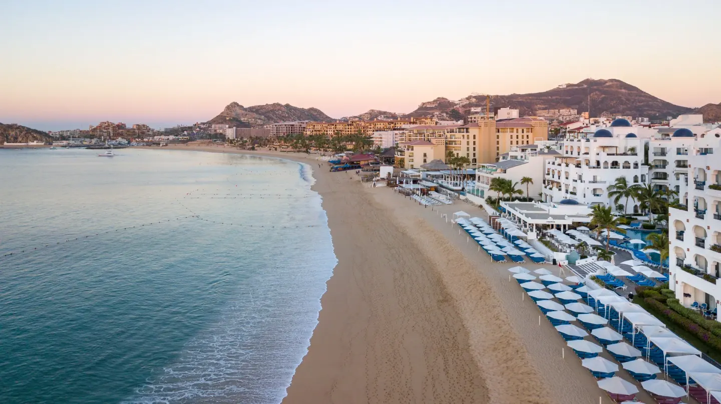 Beachfront resort buildings and rows of umbrellas at Pueblo Bonito Los Cabos Blanco.