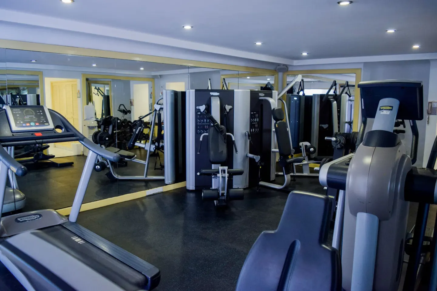 Fitness room with treadmills, weight machines, and mirrors at Pueblo Bonito Los Cabos Blanco.