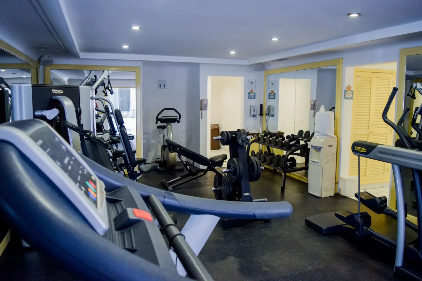 Fitness room with treadmill foreground and dumbbell rack at Pueblo Bonito Los Cabos Blanco.