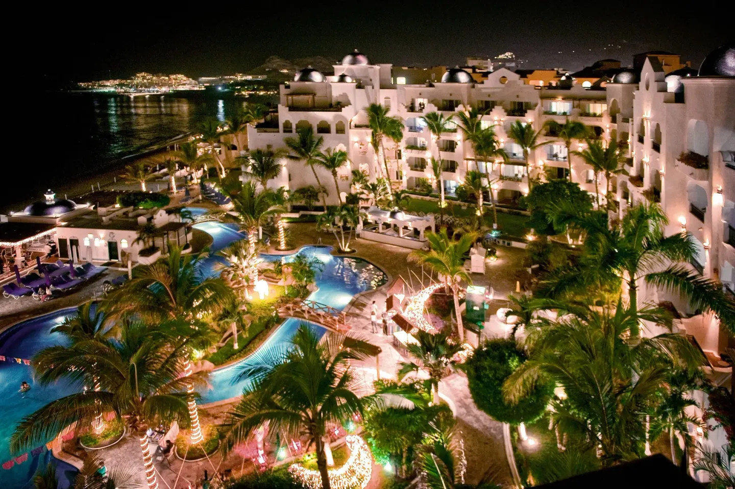 Night view of pools, palms, and illuminated buildings at Pueblo Bonito Los Cabos Blanco.