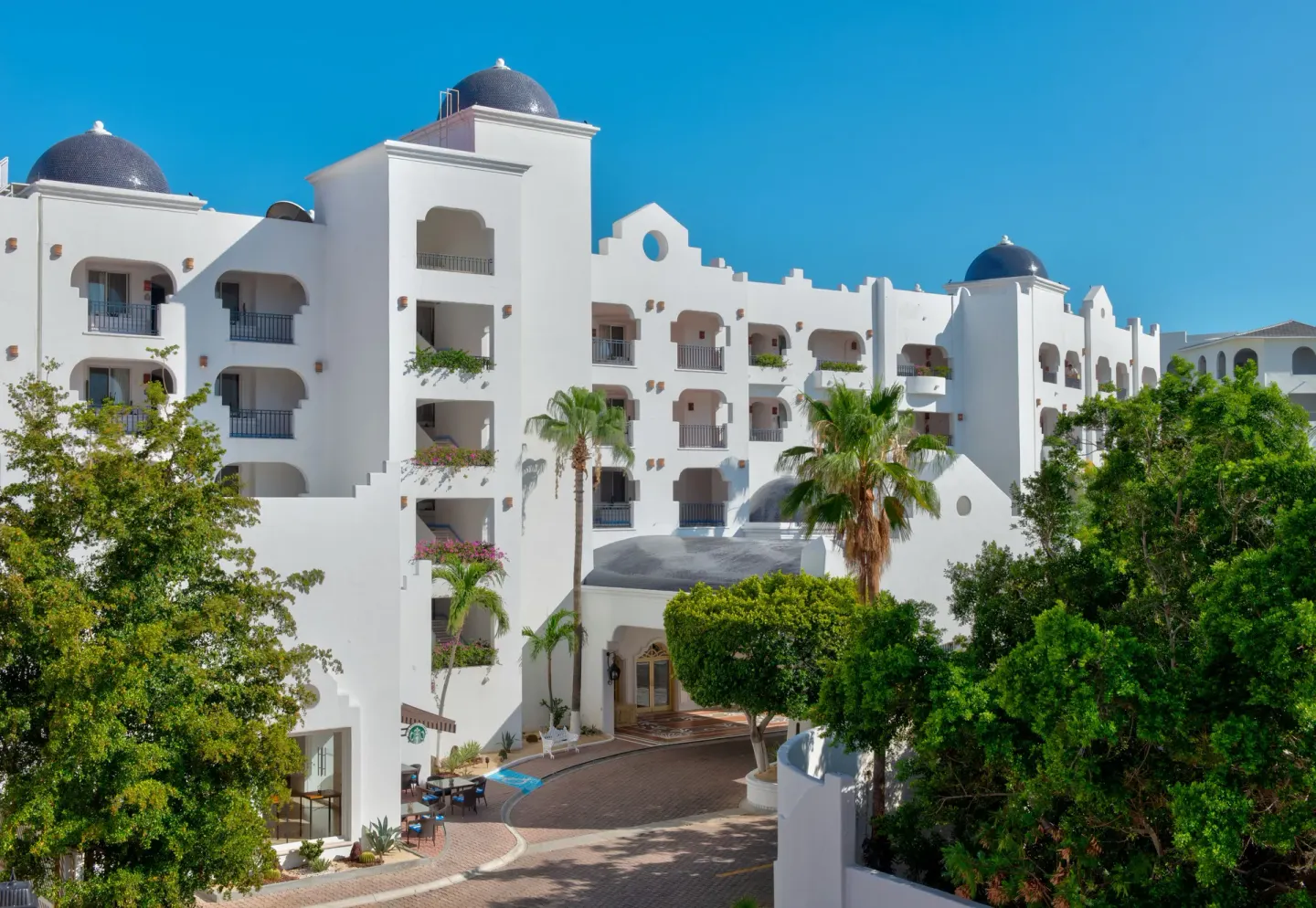 White resort building with domed towers and palms at Pueblo Bonito Los Cabos Blanco.