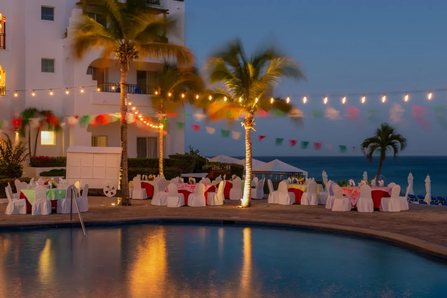 Evening poolside event setup with ocean beyond at Pueblo Bonito Los Cabos Blanco.