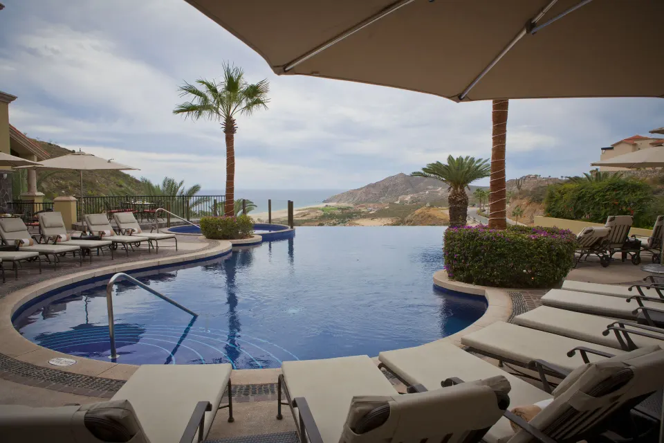 Infinity pool with loungers and ocean views at Pueblo Bonito Montecristo Luxury Villas.