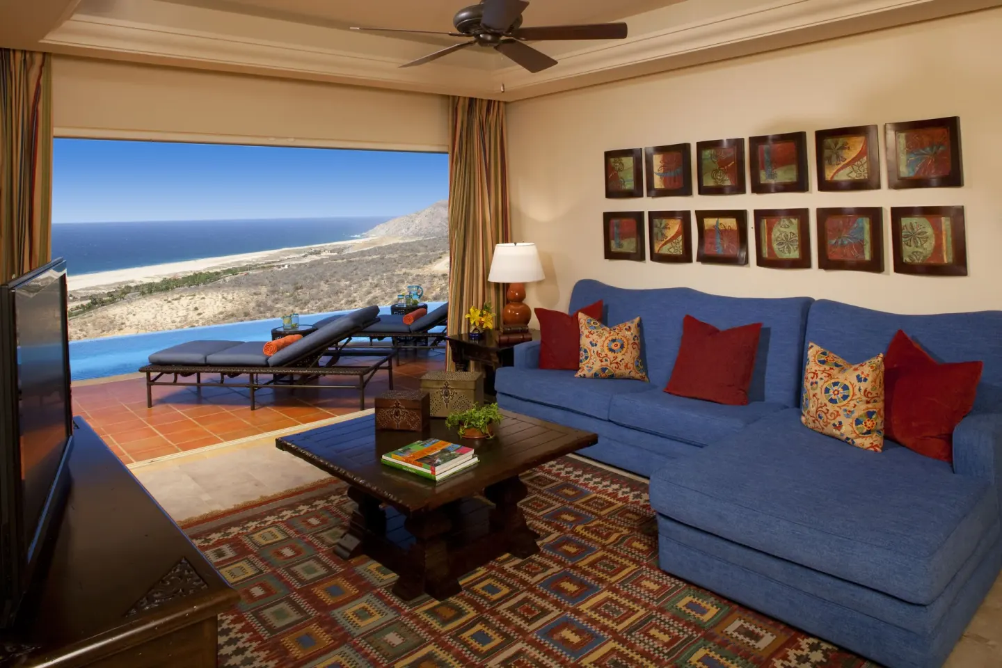 Living room with blue sectional and ocean-view terrace at Pueblo Bonito Montecristo Luxury Villas.