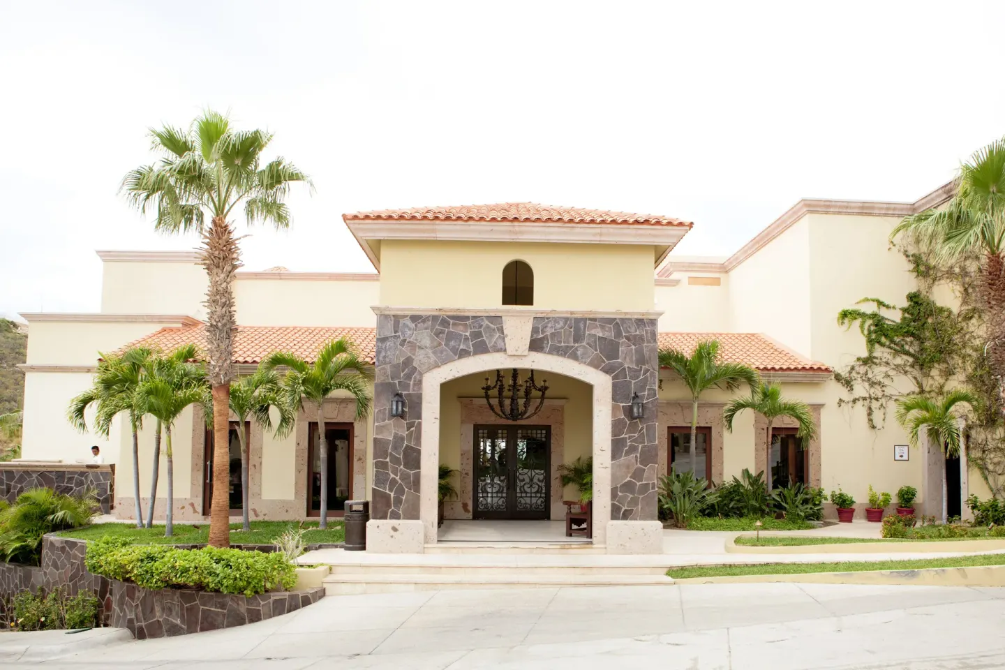 Resort entrance with palms and stone arch at Pueblo Bonito Montecristo Luxury Villas.