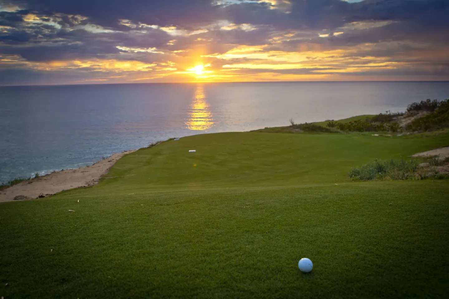Golf fairway and ball at sunset at Pueblo Bonito Montecristo Luxury Villas.