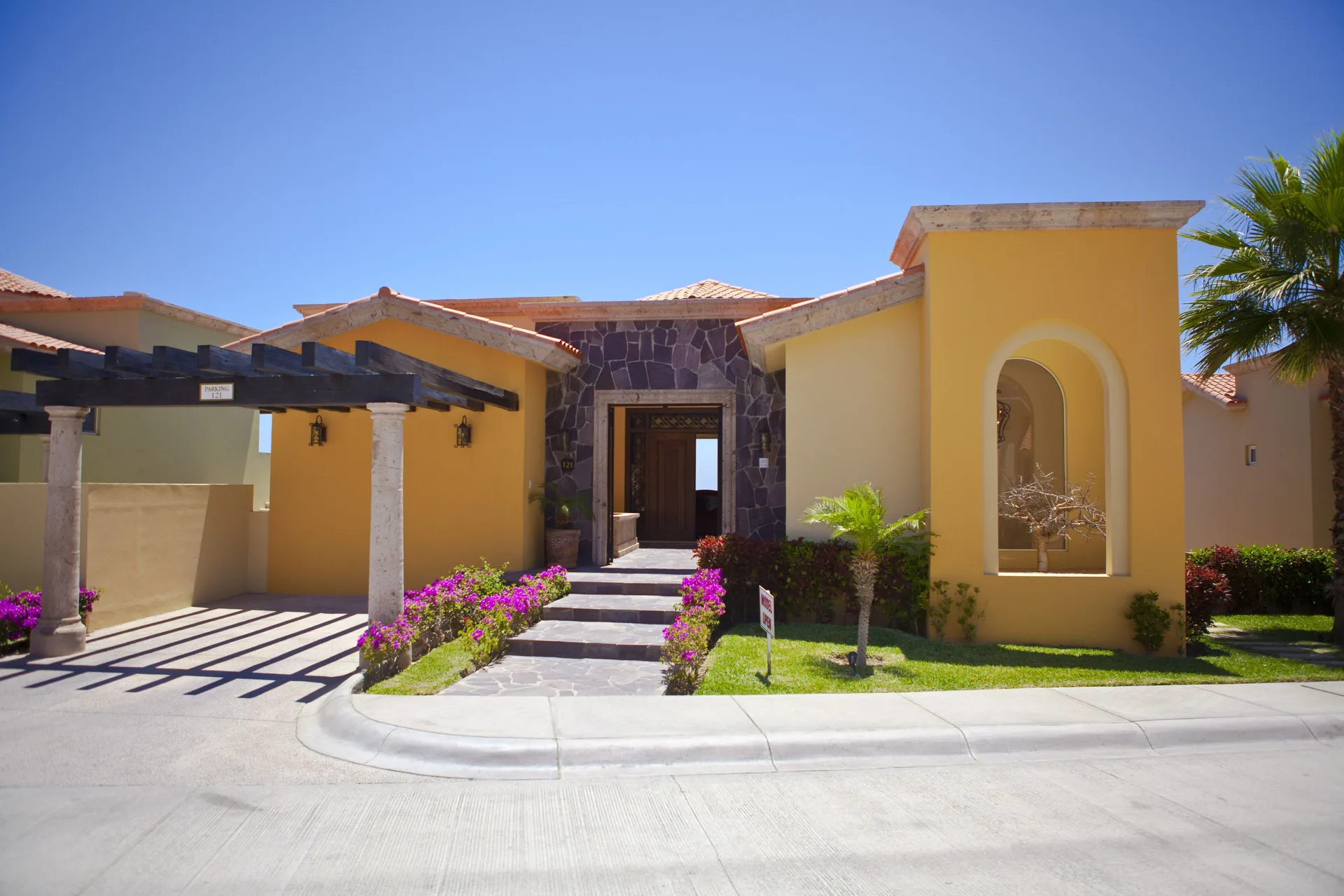 Yellow villa exterior with flowering walkway at Pueblo Bonito Montecristo Luxury Villas.
