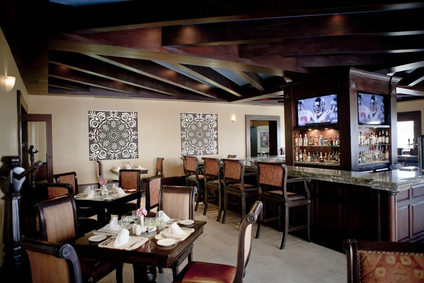 Dining tables and a bar inside Pueblo Bonito Montecristo Luxury Villas.