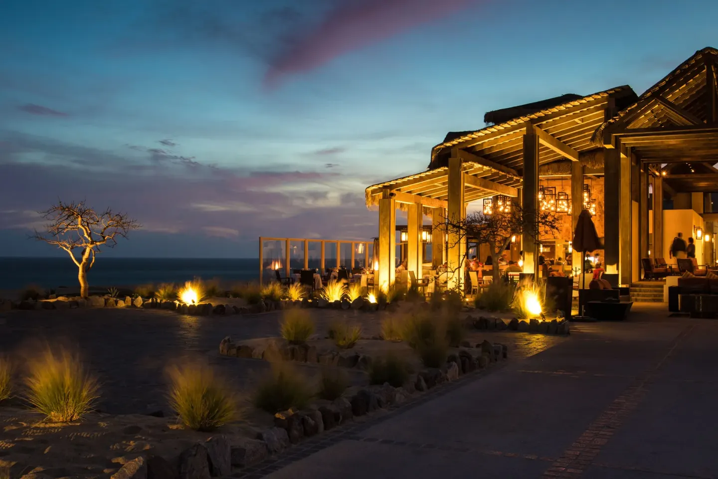 Open-air restaurant terrace at dusk at Pueblo Bonito Pacifica Golf & Spa Resort.