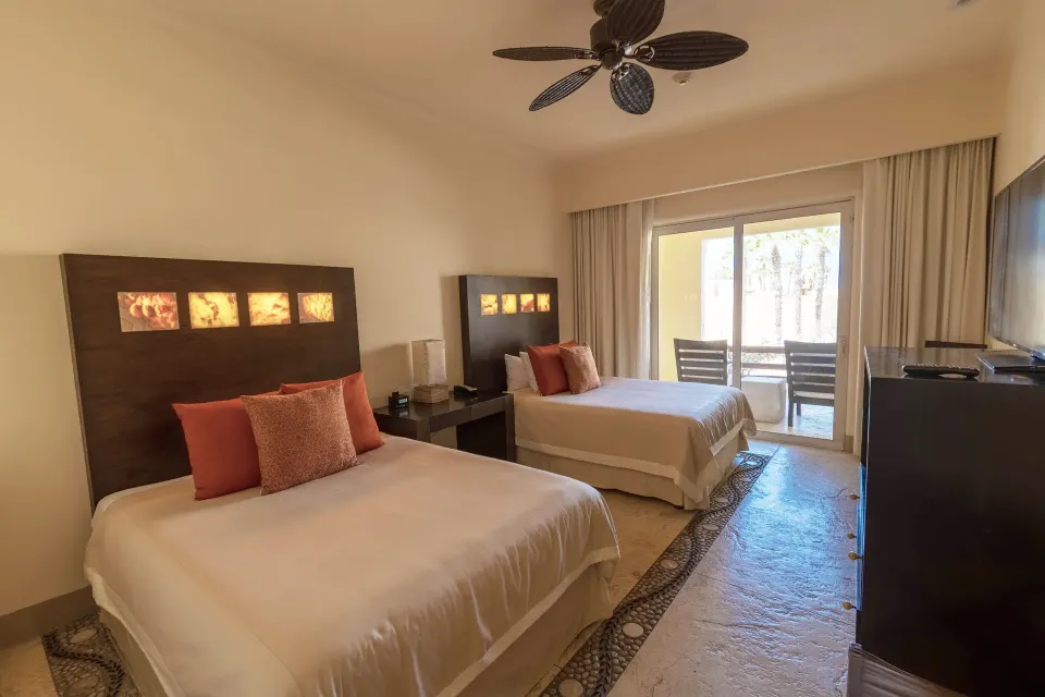 Deluxe Room with two beds and balcony doors at Pueblo Bonito Pacifica Golf & Spa Resort.