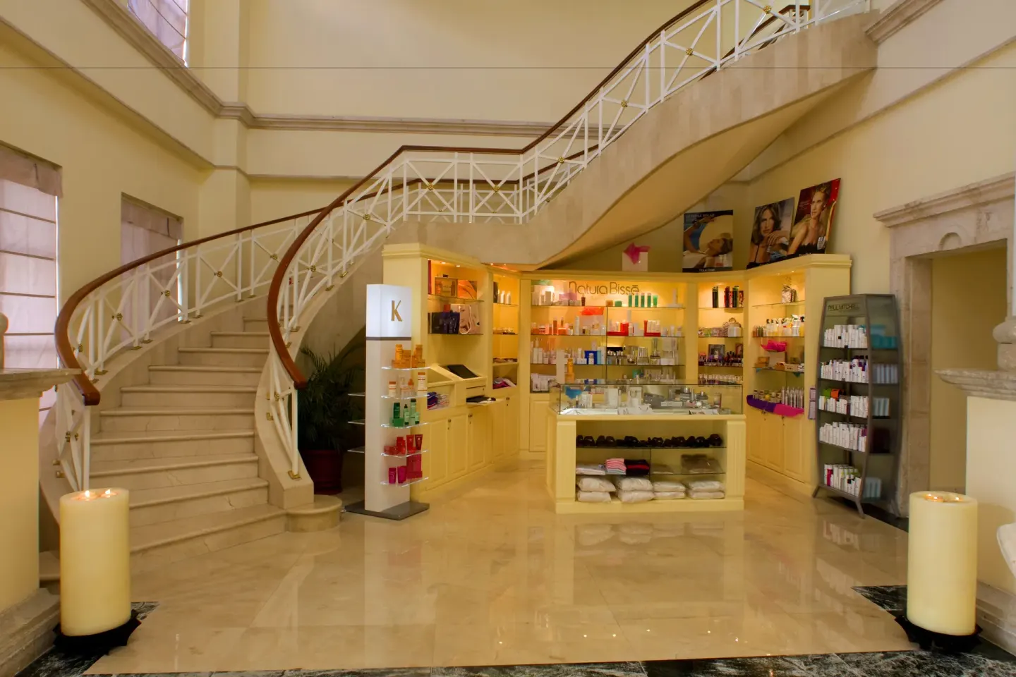 A spa retail display sits beneath a curved staircase at Pueblo Bonito Rose Resort and Spa.