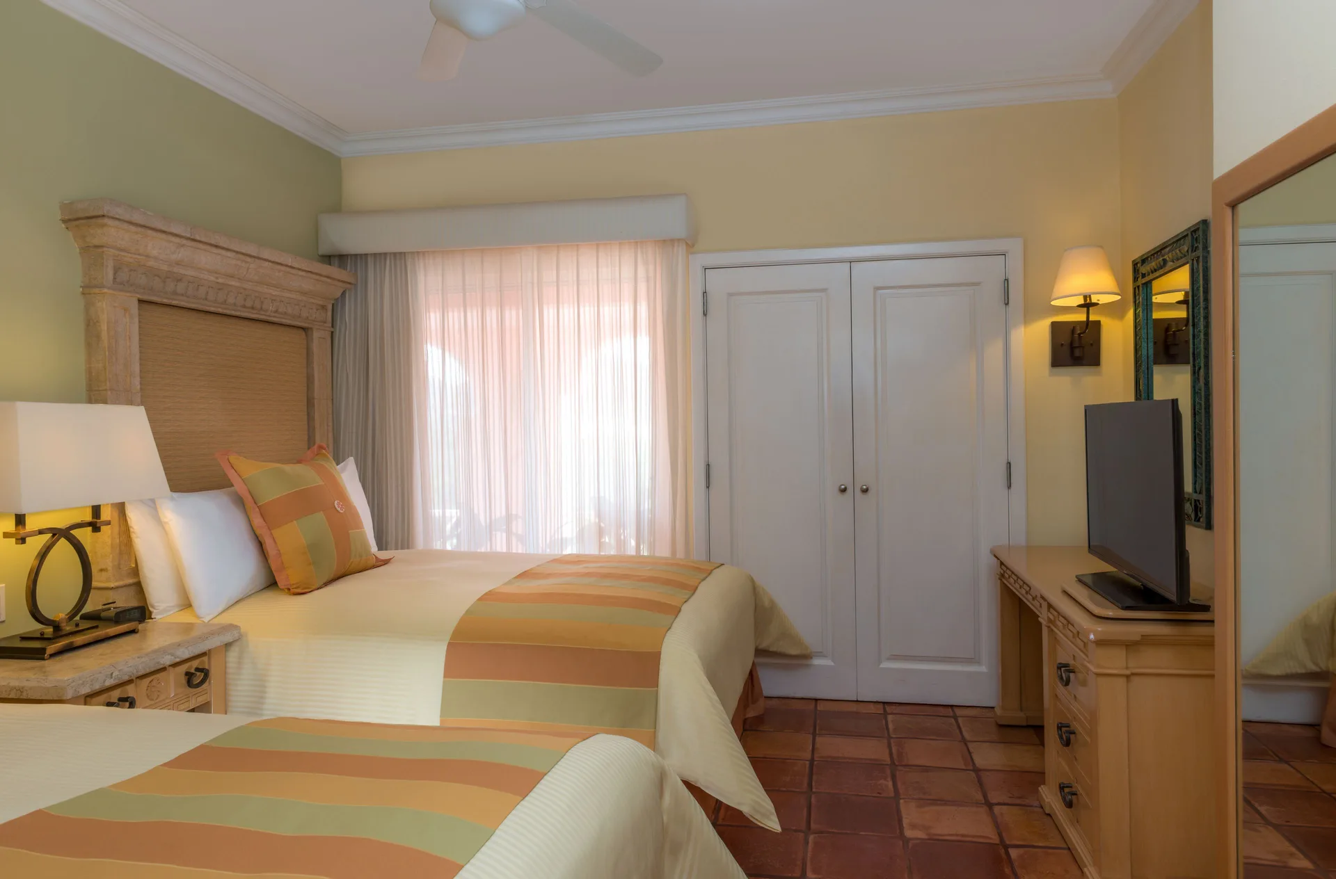 Luxury Suite bedroom with two beds, dresser and TV at Pueblo Bonito Rose Resort and Spa.