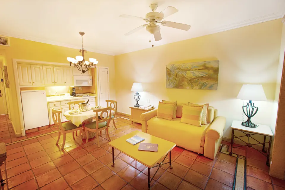 Luxury Suite living area with sofa, dining table and kitchenette at Pueblo Bonito Rose Resort and Spa.