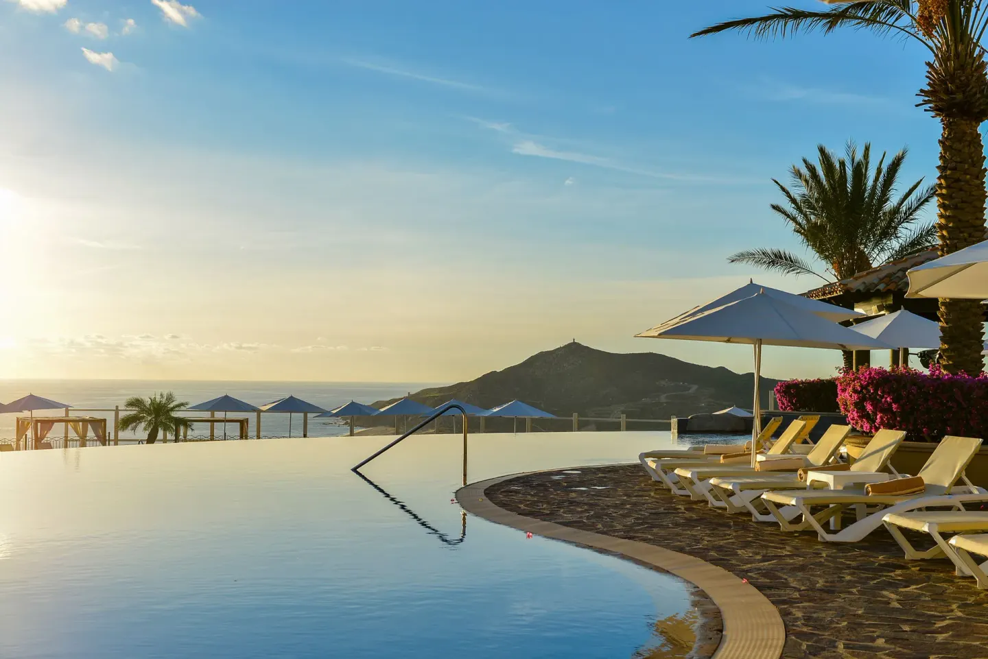 Infinity pool with lounge chairs and mountain view at Pueblo Bonito Sunset Beach Golf & Spa Resort.