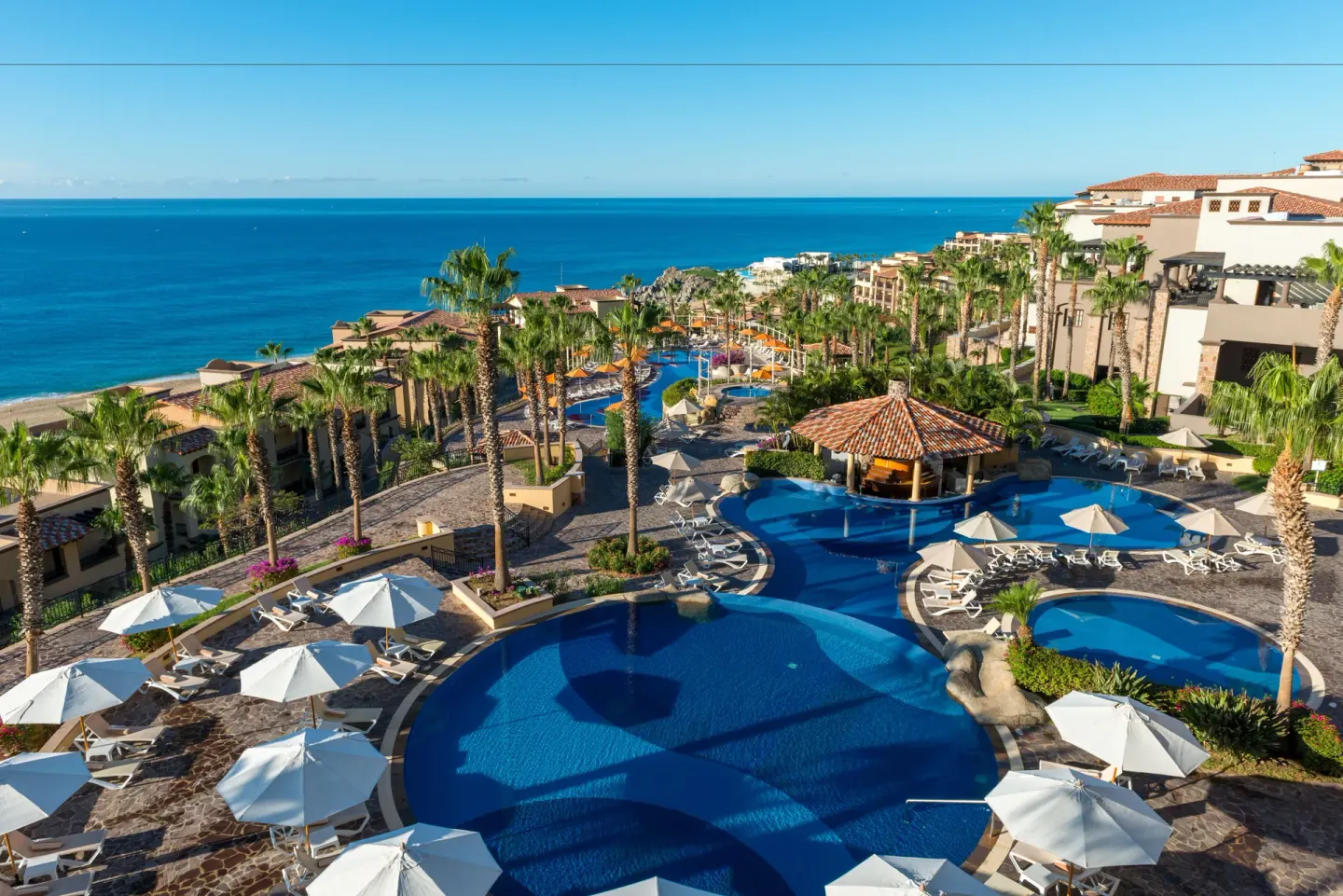 Terraced pools and palm-lined resort grounds at Pueblo Bonito Sunset Beach Golf & Spa Resort.