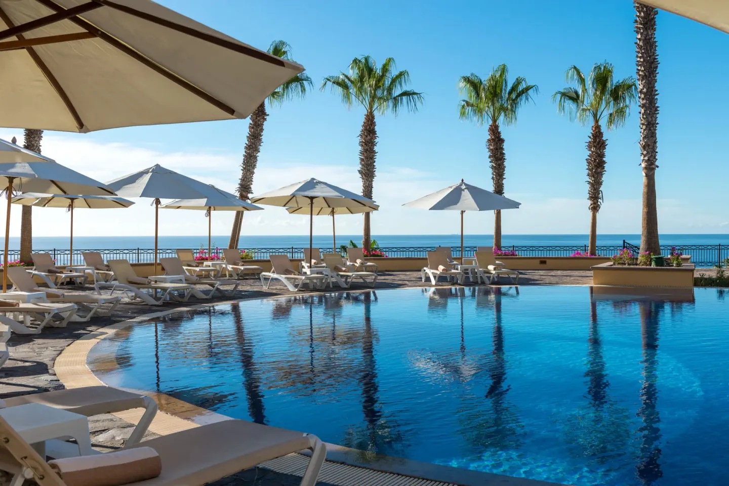 Pool deck with white umbrellas and ocean view at Pueblo Bonito Sunset Beach Golf & Spa Resort.