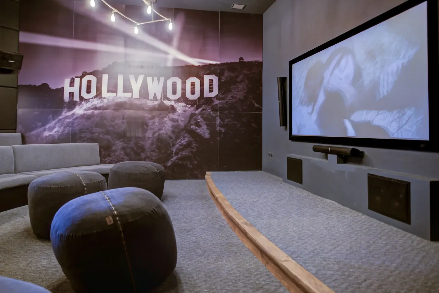 Screening room with sofas, ottomans, and a large screen at Pueblo Bonito Sunset Beach Golf & Spa Resort.