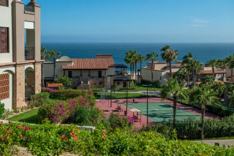 Tennis court, palms, gardens, and ocean view at Pueblo Bonito Sunset Beach Golf & Spa Resort.