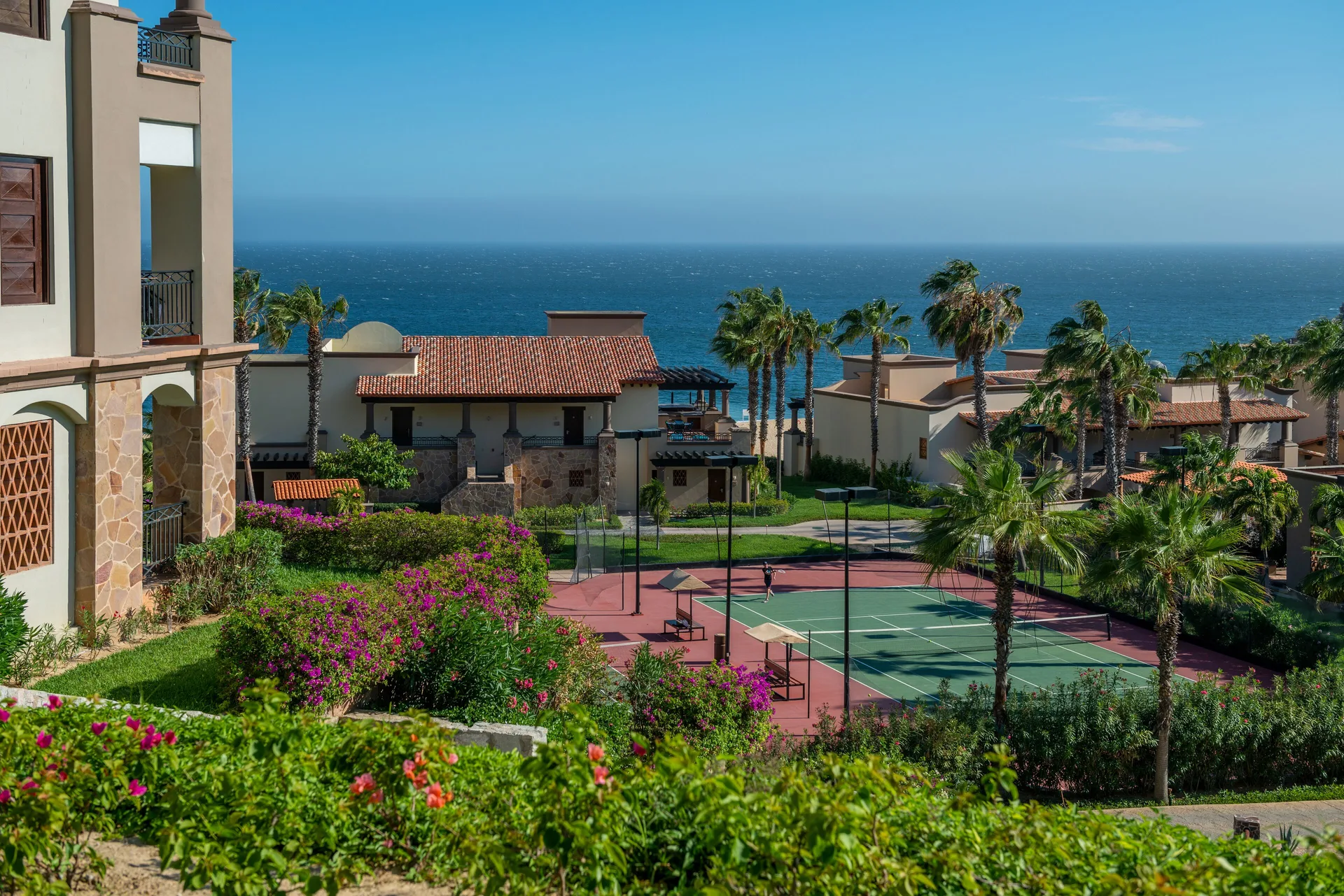 Tennis court, palms, gardens, and ocean view at Pueblo Bonito Sunset Beach Golf & Spa Resort.