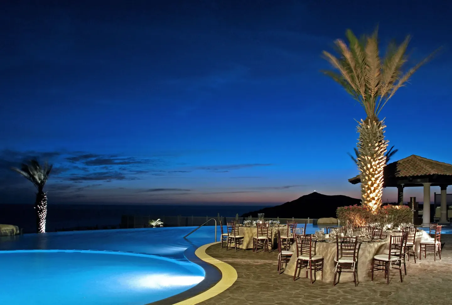 Poolside event tables at twilight at Pueblo Bonito Sunset Beach Golf & Spa Resort.