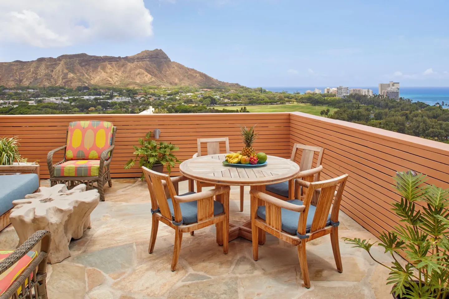 Private terrace with dining table and Diamond Head view at Queen Kapiolani Hotel.