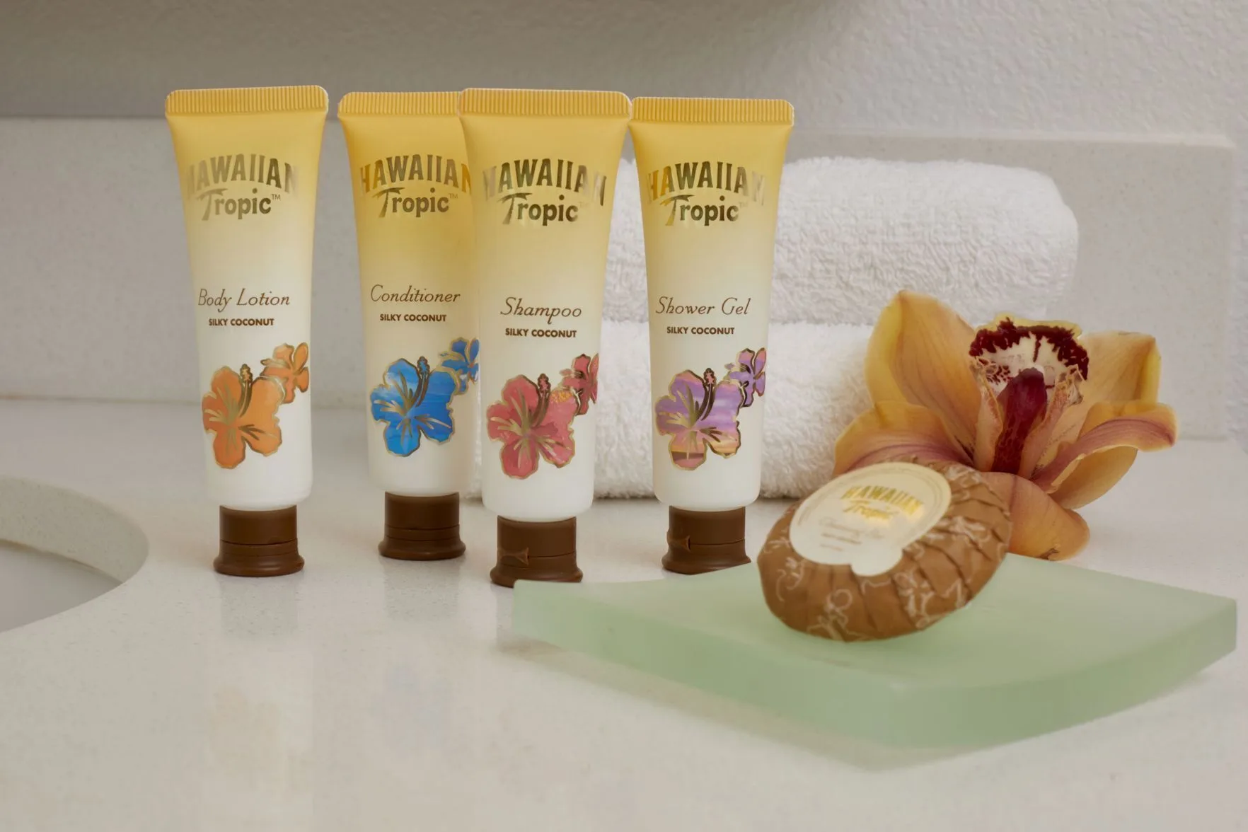 Bath amenities, towels, soap, and an orchid in a Diamond Head View room at Queen Kapiolani Hotel.