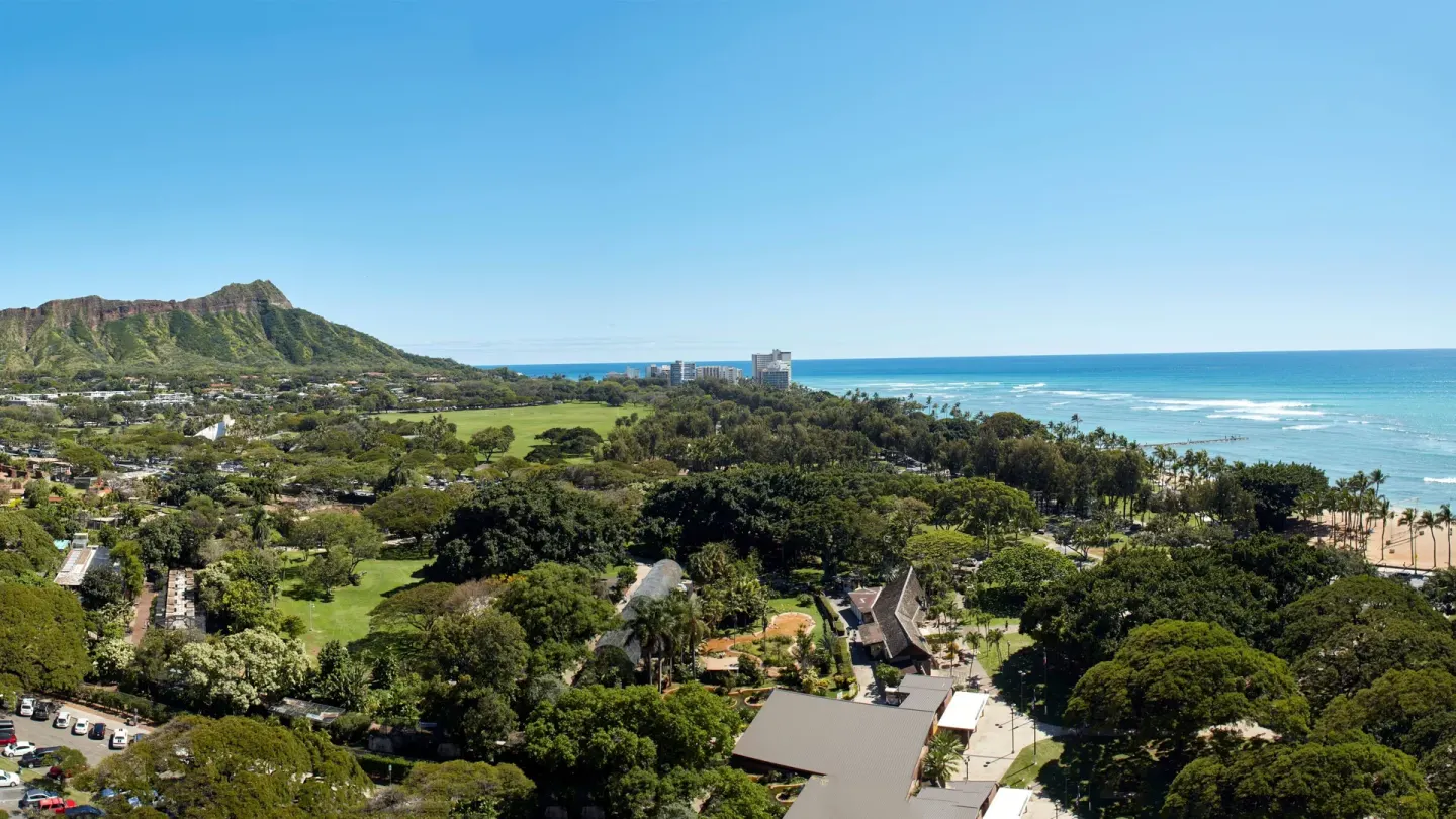Junior Suite view of Diamond Head, parkland, and ocean at Queen Kapiolani Hotel.