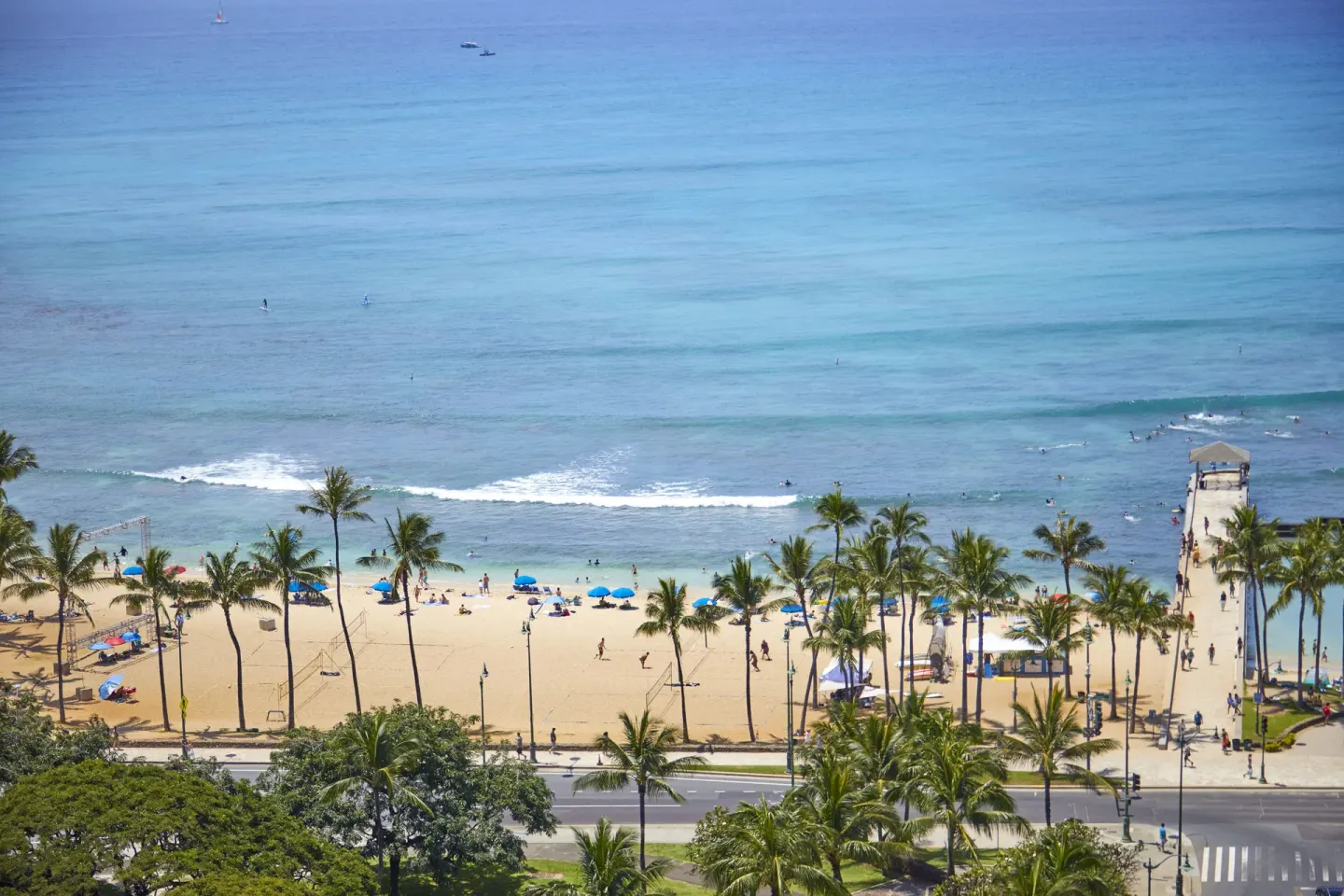 Ocean view from a studio room at Queen Kapiolani Hotel overlooking Waikiki Beach and palm trees.