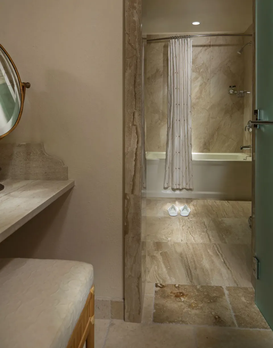 Bathroom view through doorway showing tub and vanity at Quintessence Hotel.