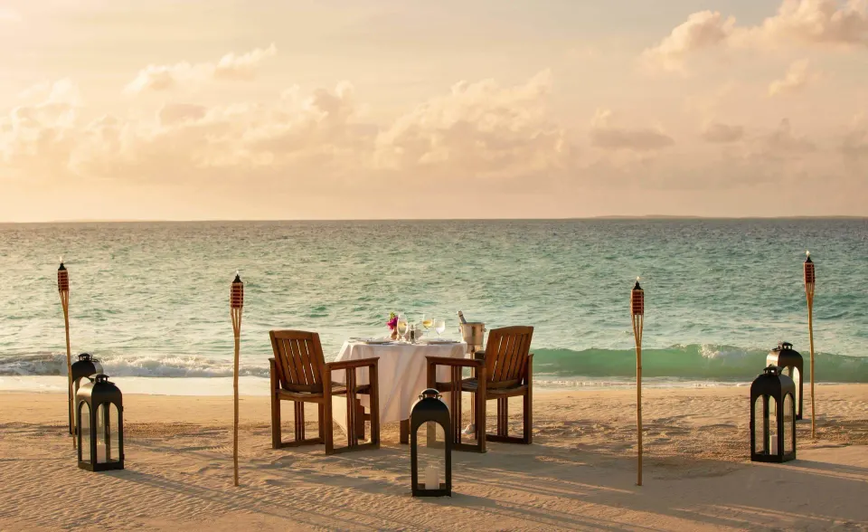 Romantic beach dining setup on sand with ocean view at Quintessence Hotel