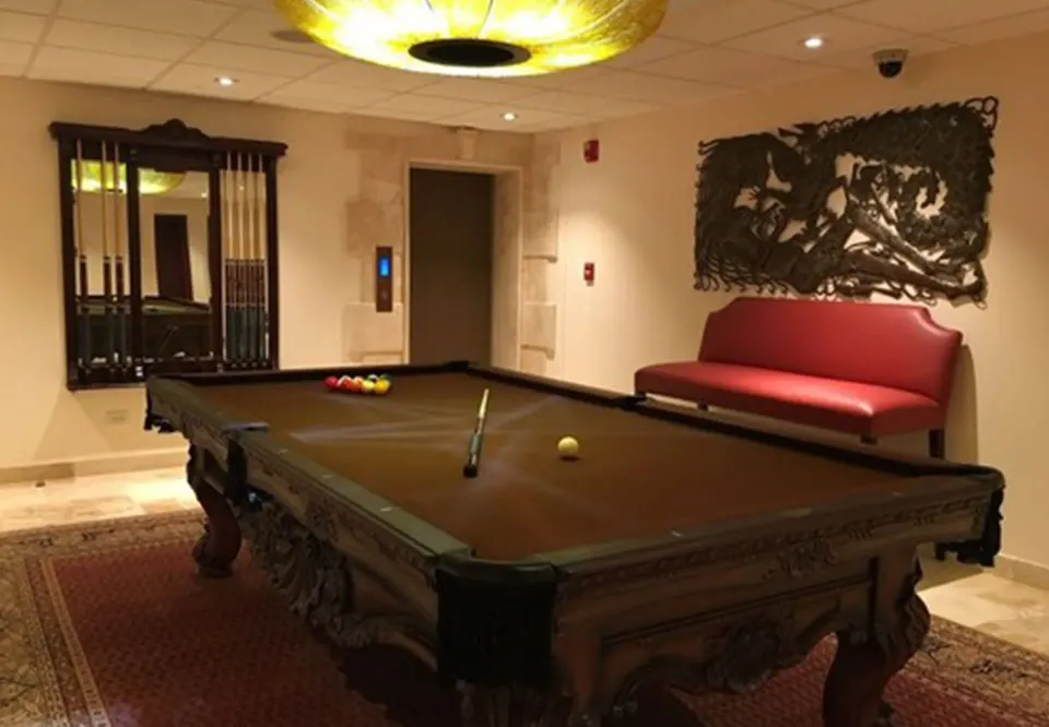 Billiards table in a softly lit games room at Quintessence Hotel.