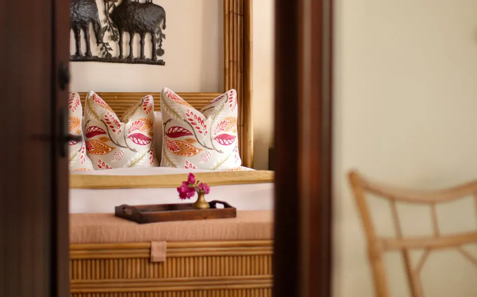 Close-up of a bed headboard and decorative pillows in a suite at Quintessence Hotel