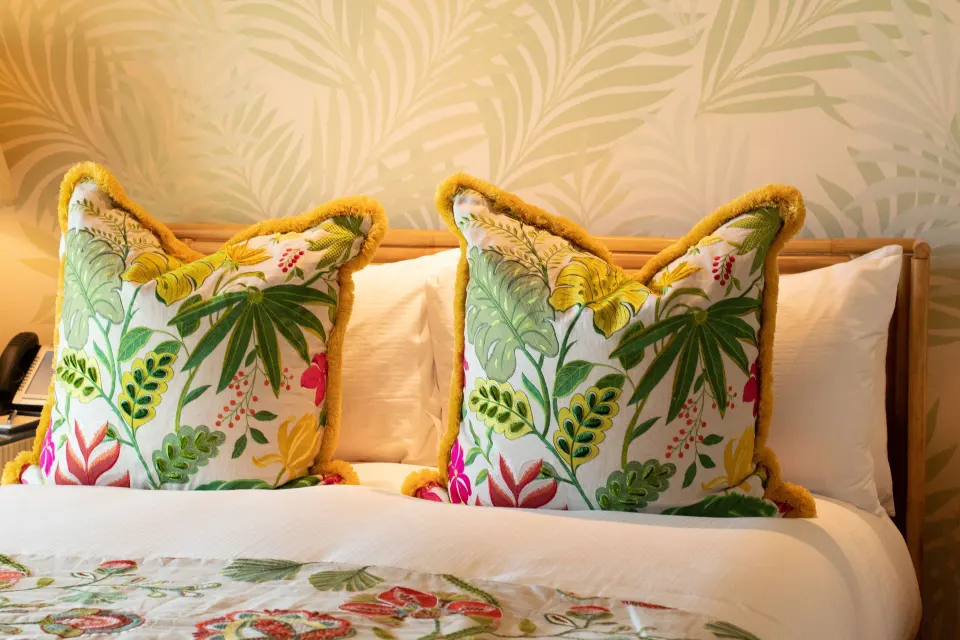 Close-up of decorative pillows on a bed at Quintessence Hotel.