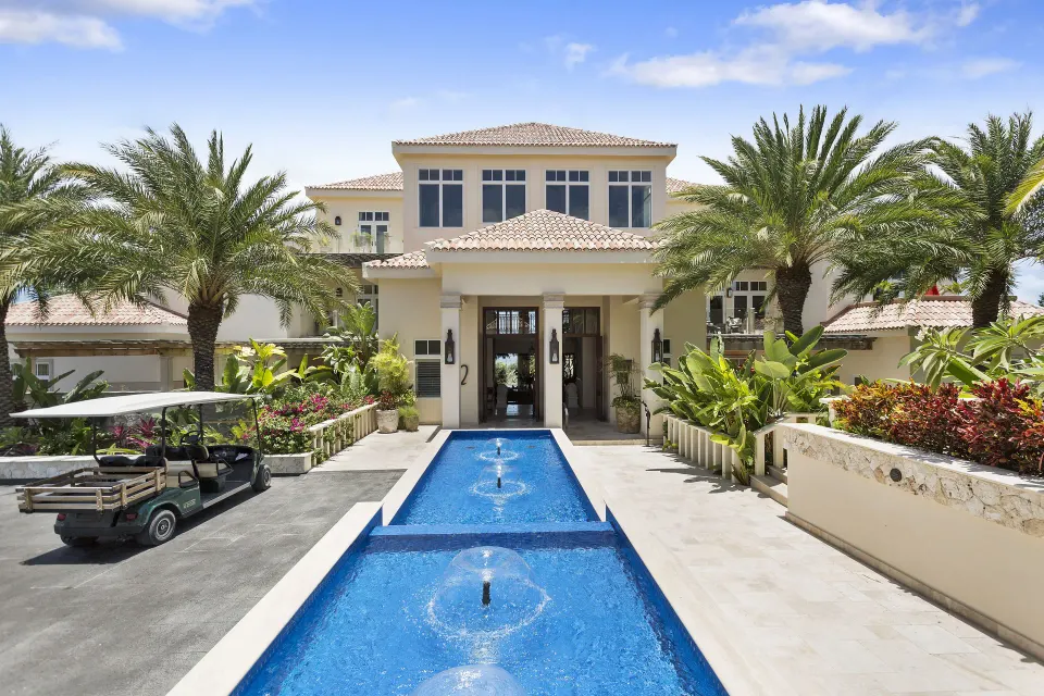 Entrance fountain and drive lined with palms leading to the resort at Quintessence Hotel