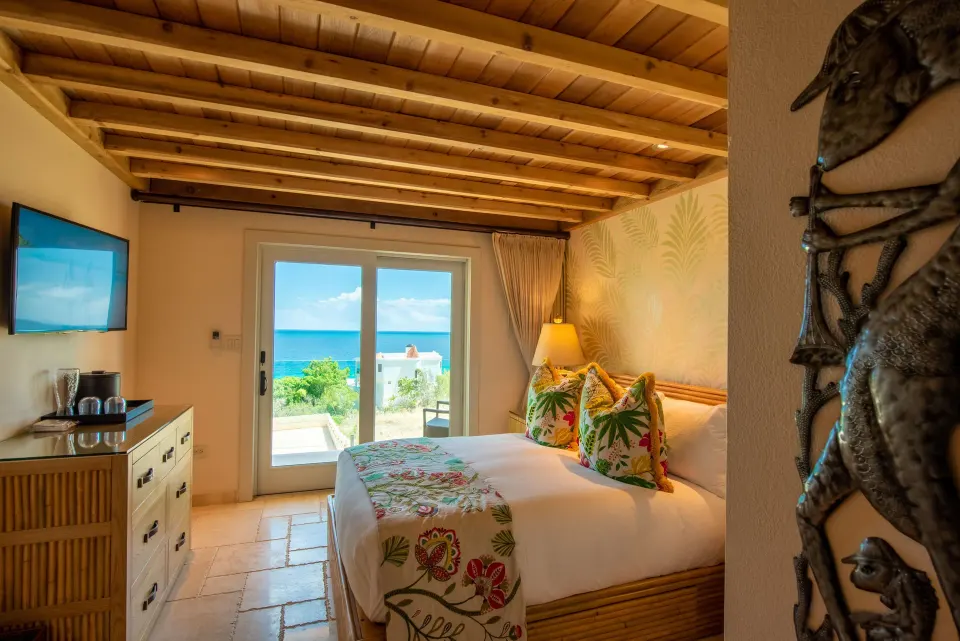 Cozy guest room with ocean view doors at Quintessence Hotel.