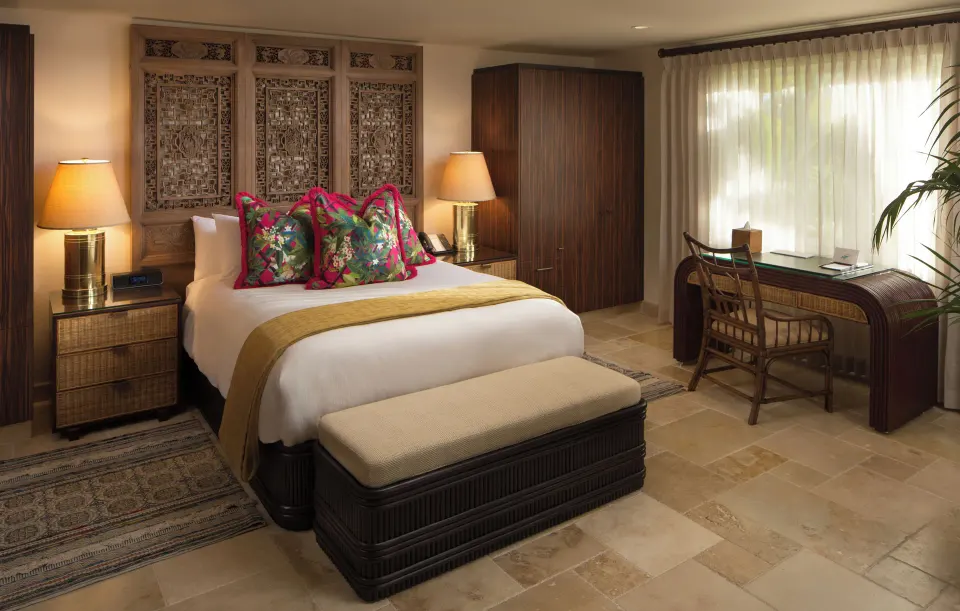 Junior Suite king bed with carved headboard and desk at Quintessence Hotel