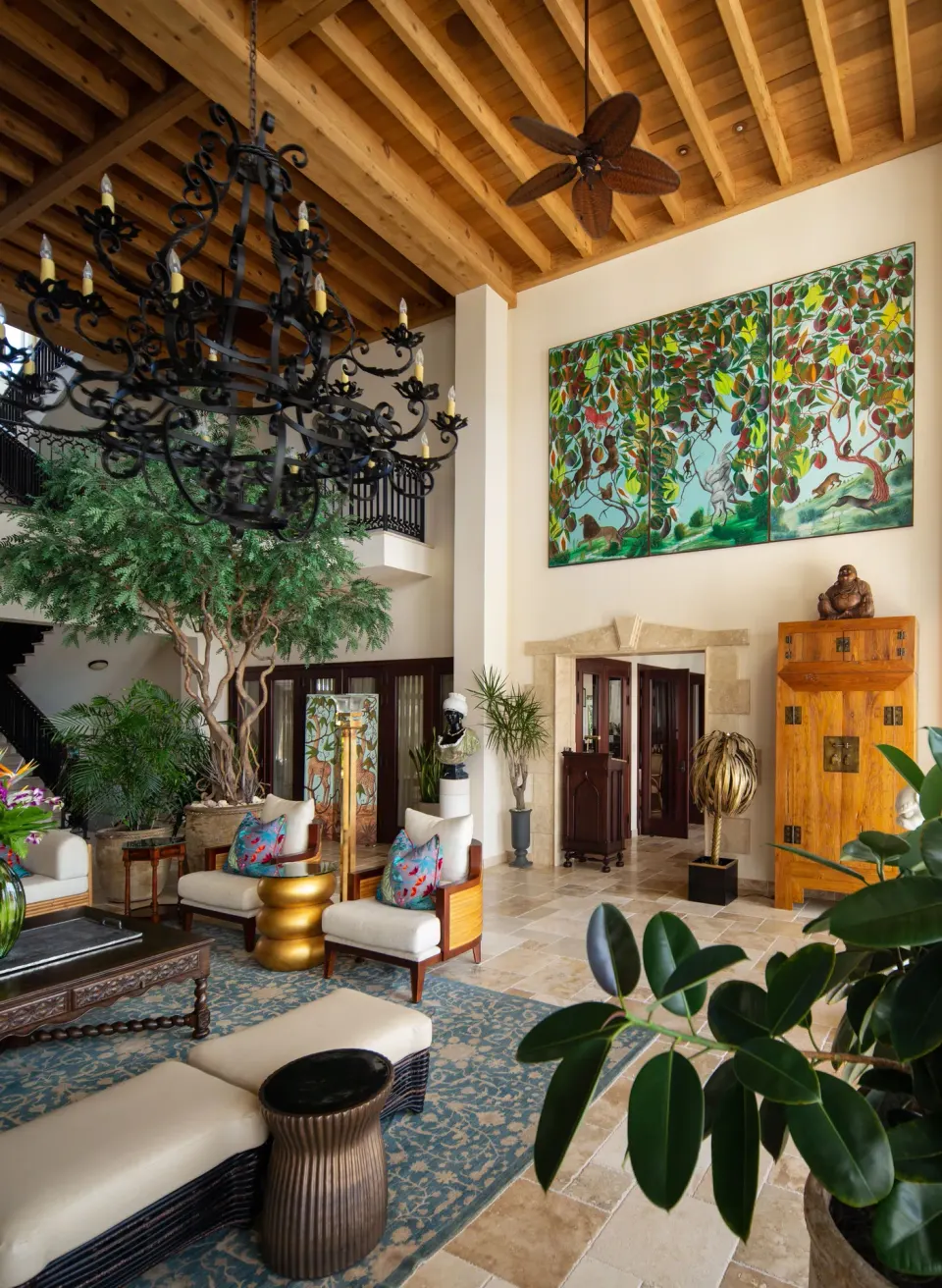 High-ceiling lobby area with large artwork and chandeliers at Quintessence Hotel
