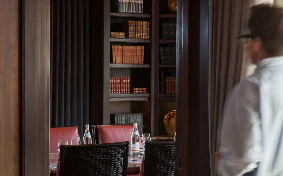 Private dining room with bookcases and table setting at Quintessence Hotel