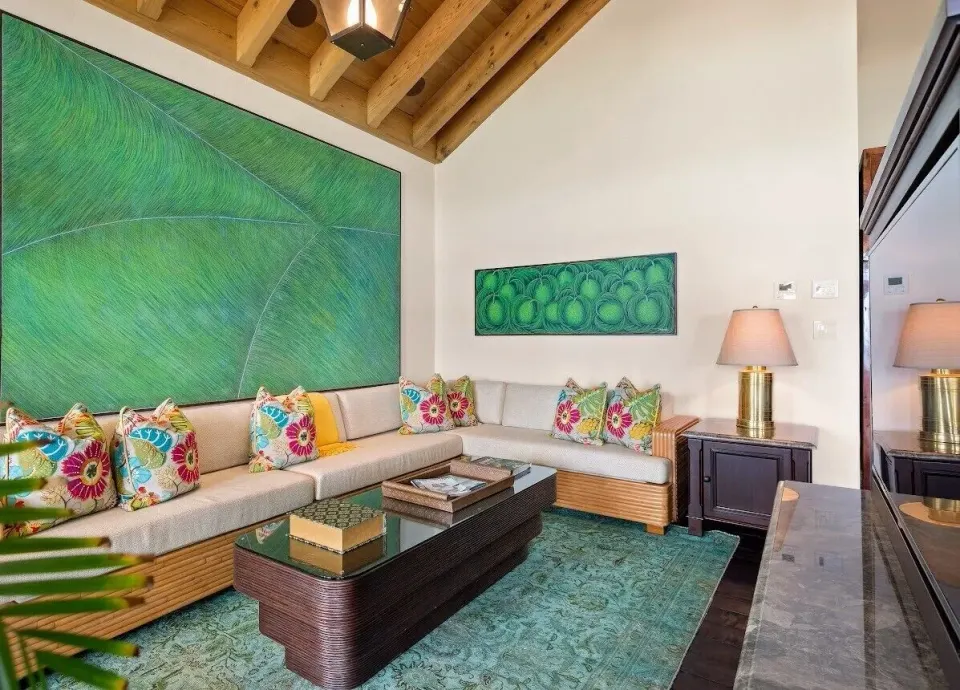 Lounge area with sectional sofa and large green artwork at Quintessence Hotel.