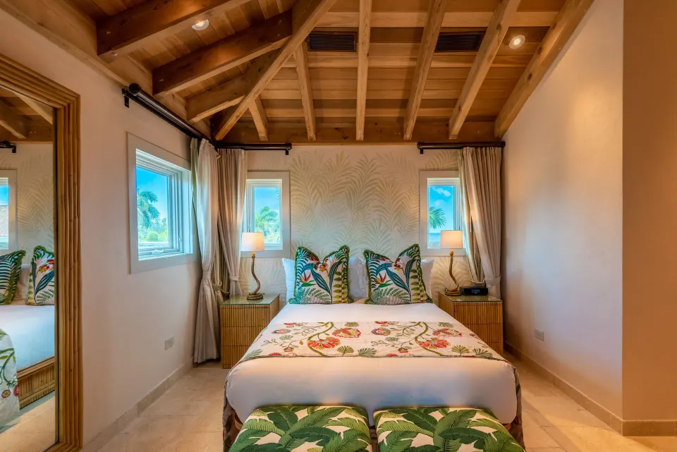 Full view of a Junior Queen Suite with queen bed, wooden ceiling and tropical accents at Quintessence Hotel