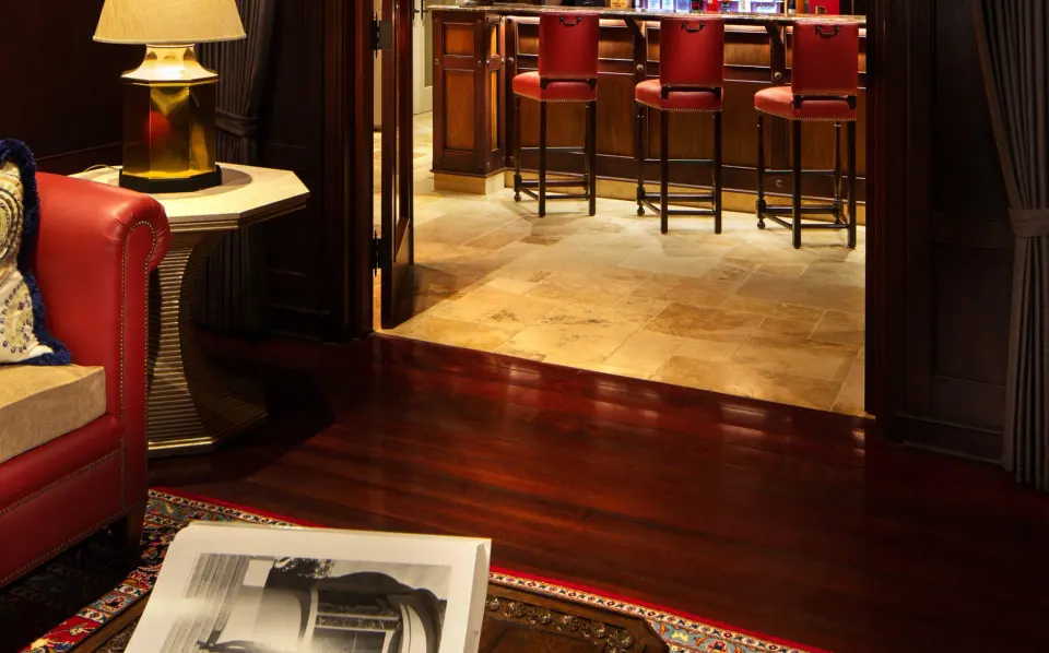View from the living area toward the bar with red stools in a Luxury Suite at Quintessence Hotel