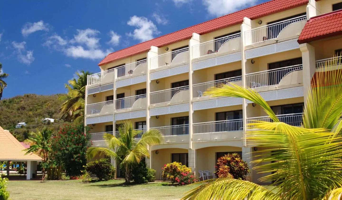 Balconied guestroom building with red roof at Radisson Grenada Beach Resort.
