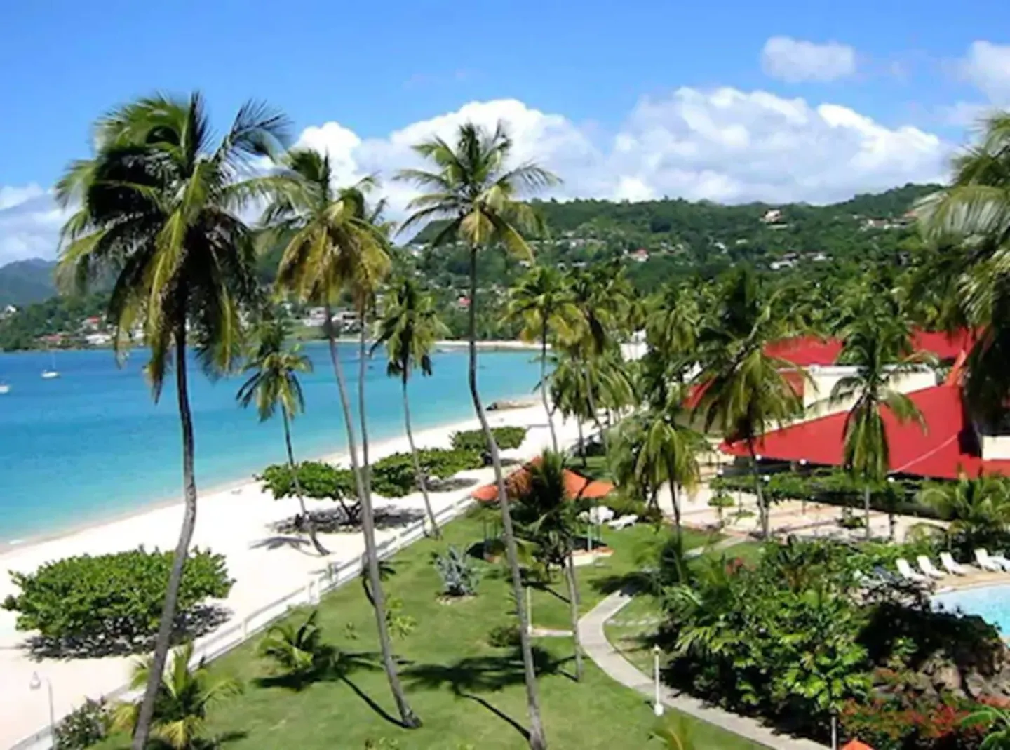 Beachfront palms, lawns, and red-roof buildings at Radisson Grenada Beach Resort.