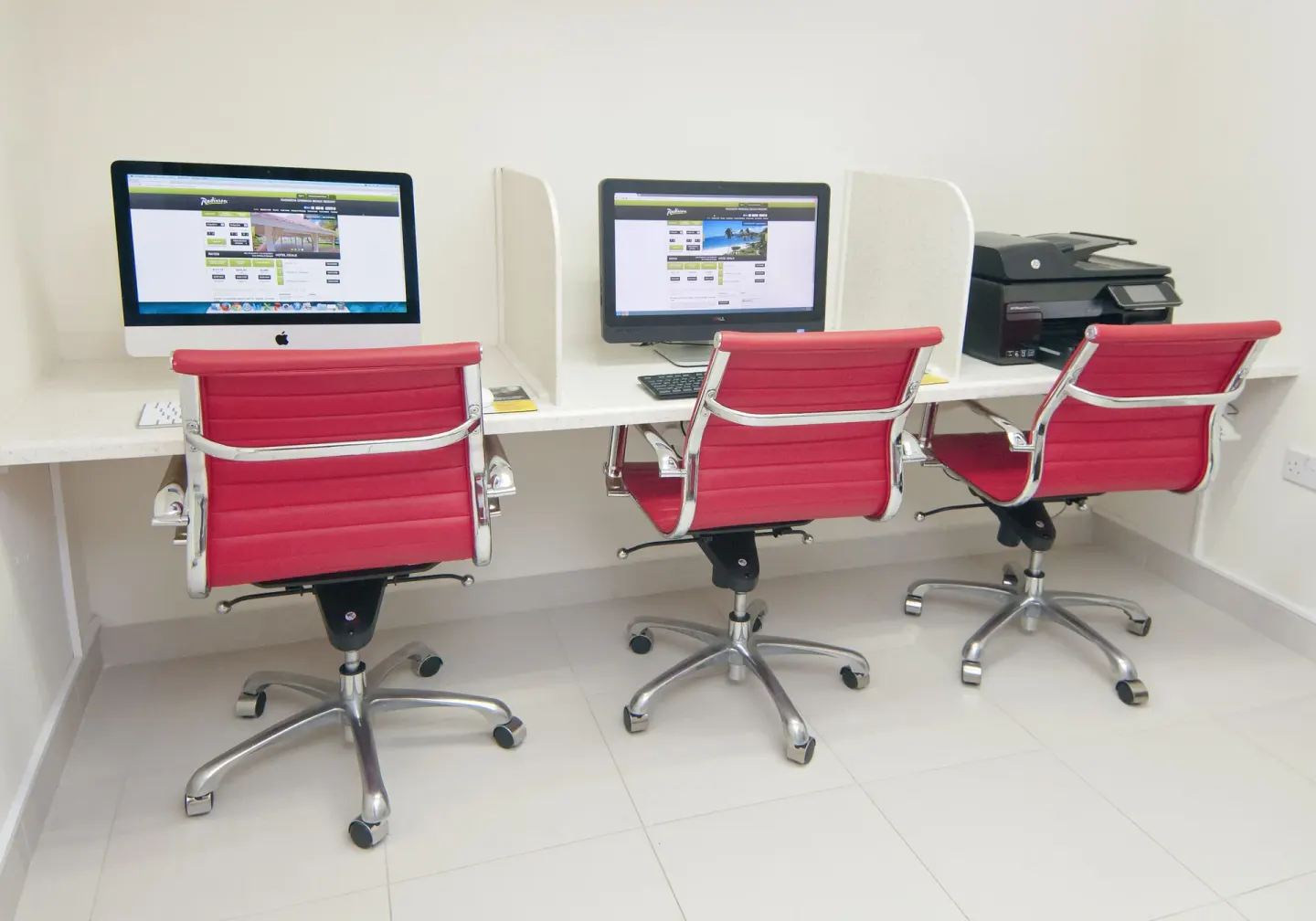 Business center computers with red chairs at Radisson Grenada Beach Resort.