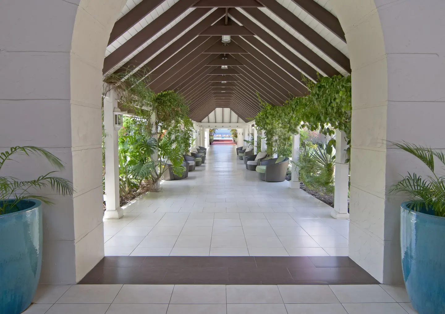 Covered resort walkway with plants and seating at Radisson Grenada Beach Resort.