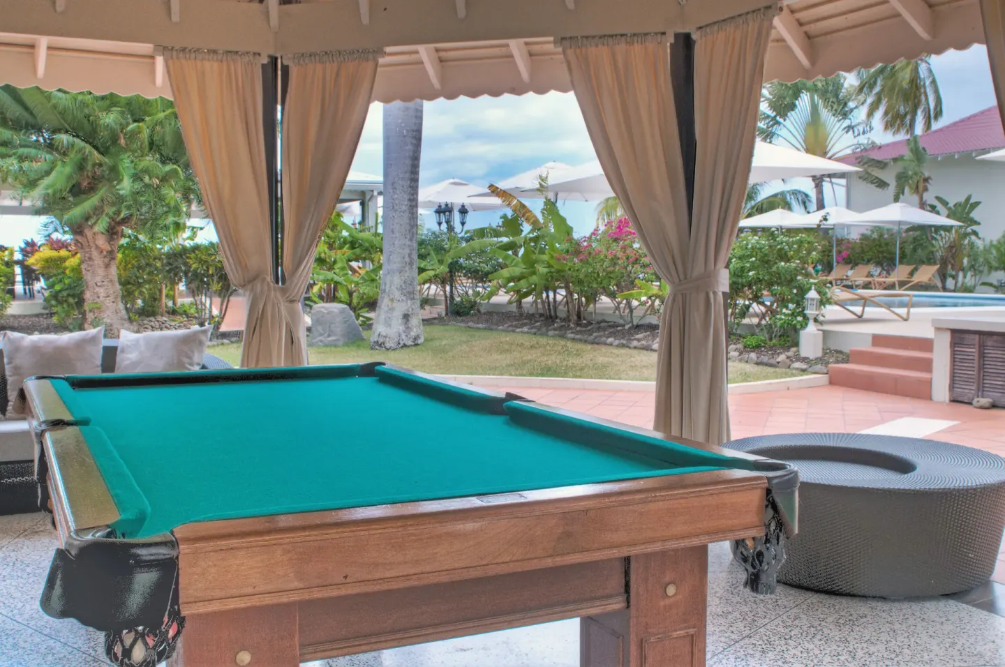 Covered pool table beside resort gardens at Radisson Grenada Beach Resort.